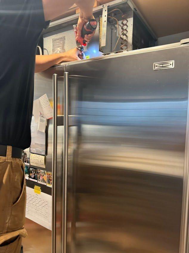 Tampa technician clearing salt-fouled condenser coils on a Sub-Zero built-in